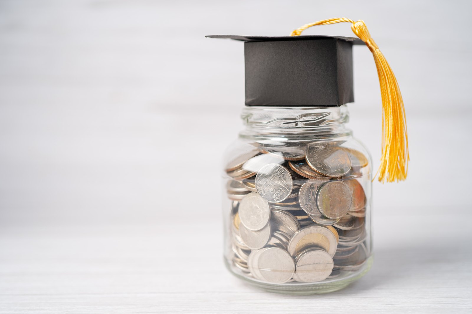An education savings jar topped with a graduation cap